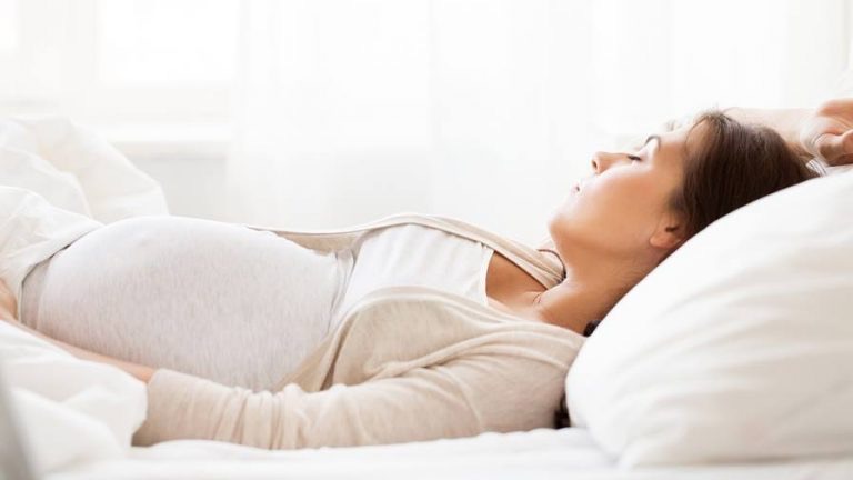 Hãy nằm ngửa hoặc nằm nghiêng bên trái khi ngủ, sử dụng gối ôm hoặc đai đeo bụng để nâng đỡ phần bụng đang ngày càng lớn